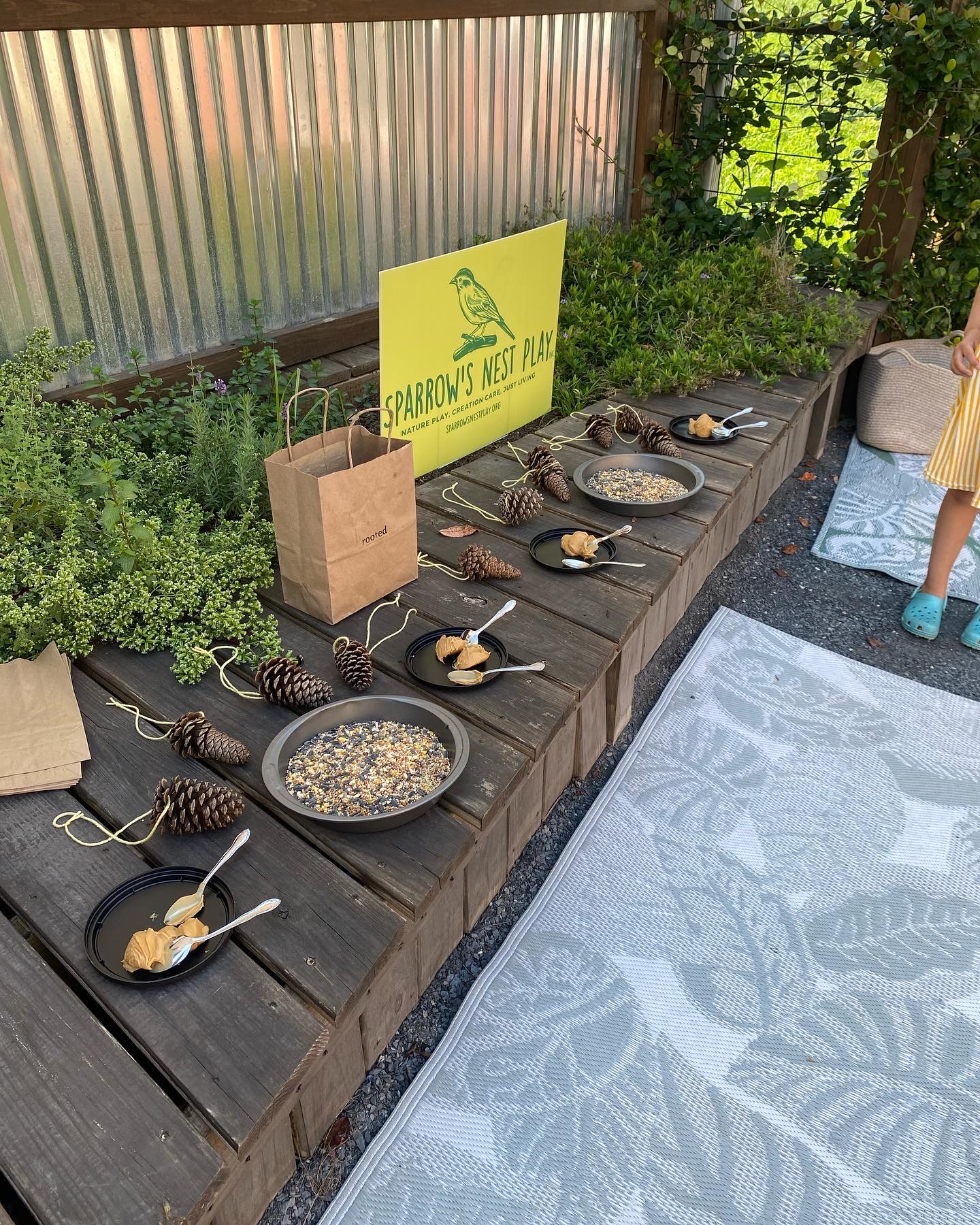 Pans with bird seed, spoons of peanut butter, pine cones, and yard can come together to make fun bird feeders!