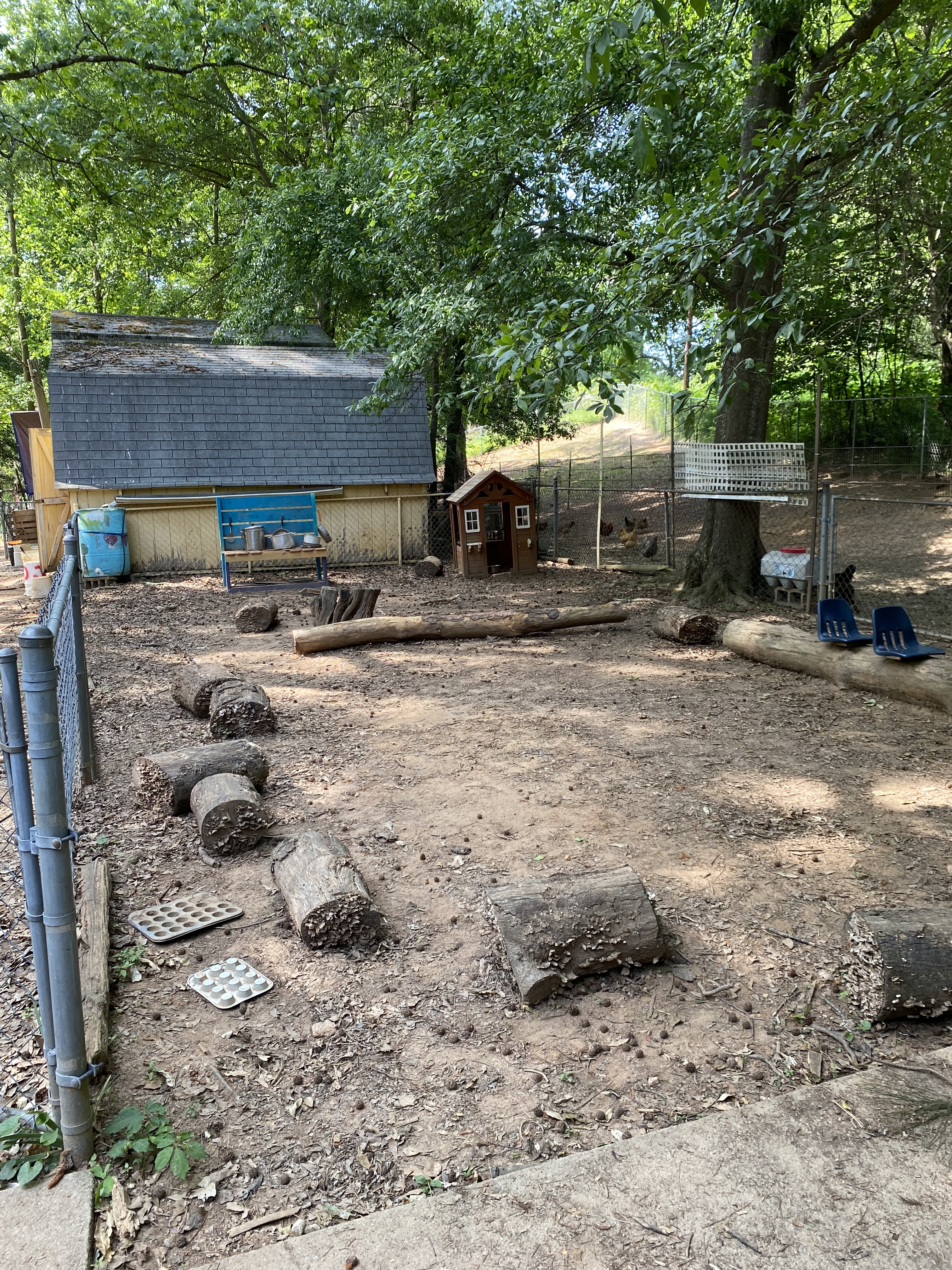 view of mud kitchen with log seating area for children