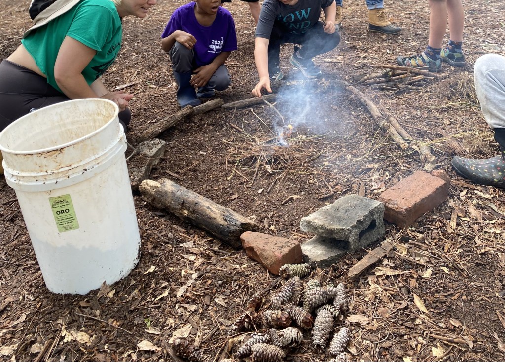 children struggle to start fire with wet supplies