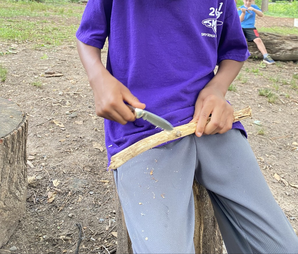 boy learns to whittle with knife